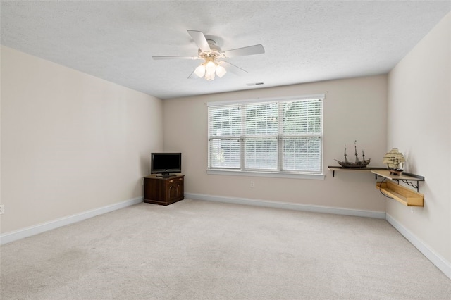 unfurnished living room with a textured ceiling, ceiling fan, and light colored carpet