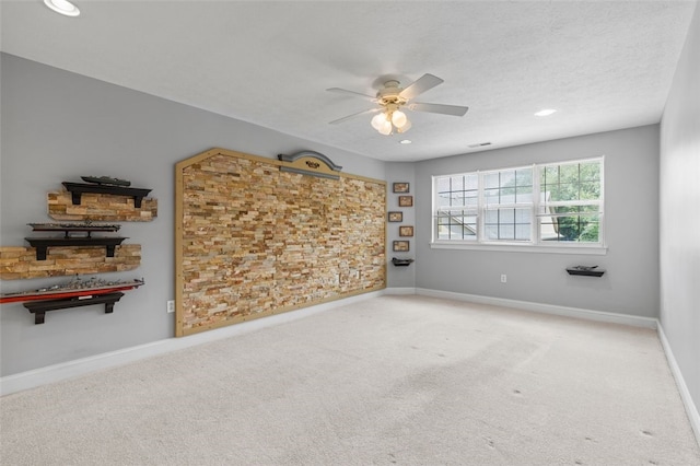 empty room featuring a textured ceiling, ceiling fan, and carpet flooring