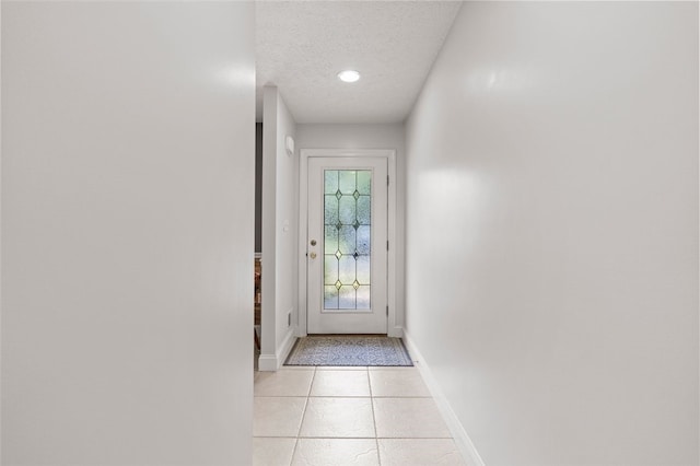 doorway featuring a textured ceiling and light tile patterned floors