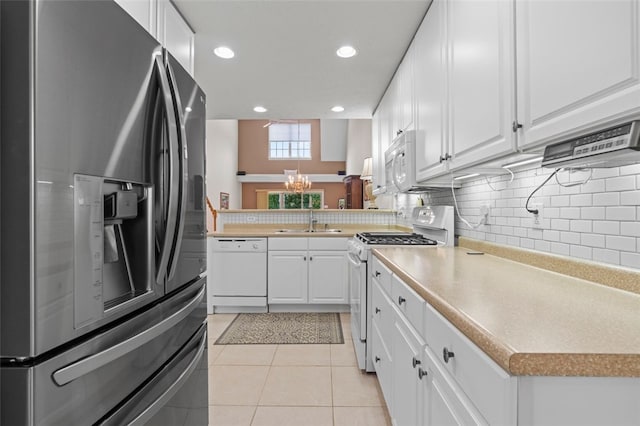 kitchen featuring light tile patterned flooring, white appliances, white cabinets, and sink