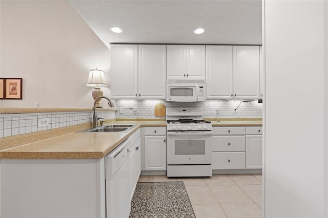 kitchen featuring white appliances, sink, decorative backsplash, white cabinets, and light tile patterned floors