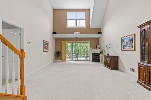 living room with light carpet, high vaulted ceiling, and a wealth of natural light