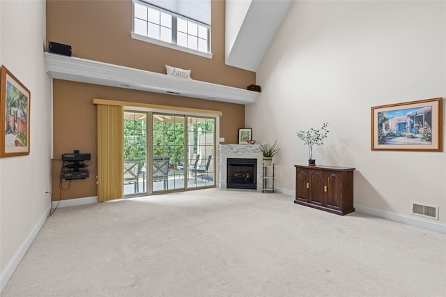 carpeted living room featuring high vaulted ceiling and a healthy amount of sunlight