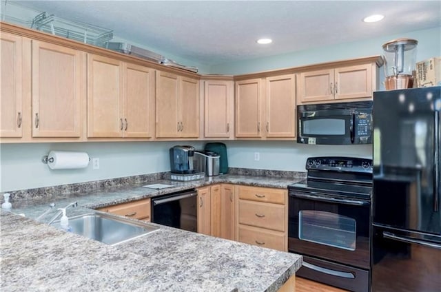 kitchen featuring light hardwood / wood-style flooring, light brown cabinetry, black appliances, and sink