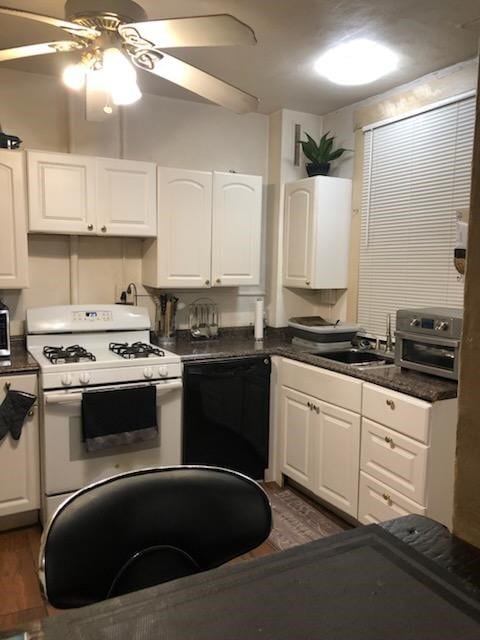 kitchen with black dishwasher, dark hardwood / wood-style floors, white cabinetry, and white gas range oven