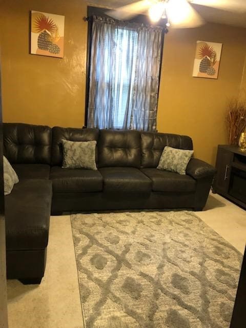 carpeted living room with ceiling fan