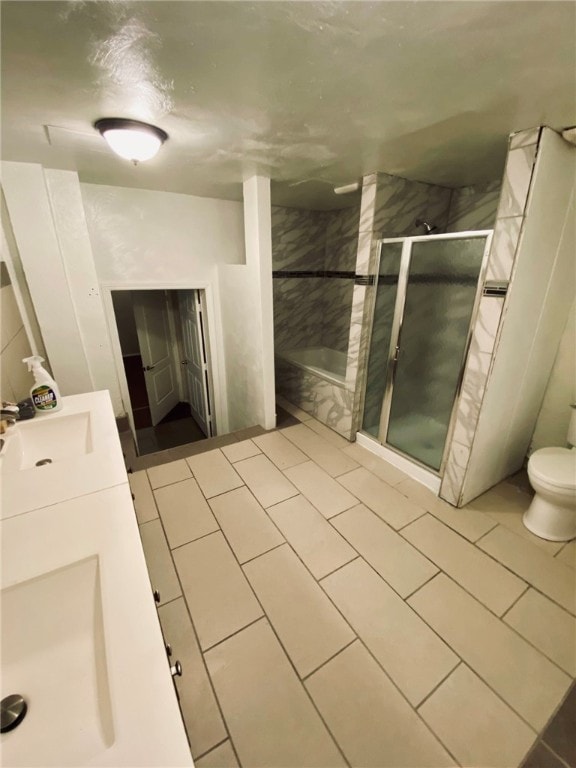 bathroom featuring vanity, toilet, tile patterned flooring, and a shower with door