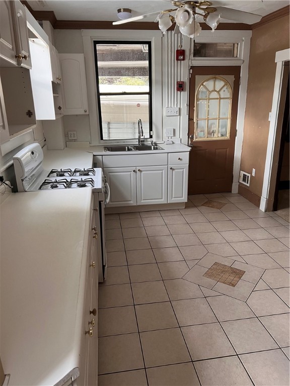 kitchen with white cabinetry, sink, white gas range, light tile patterned flooring, and ceiling fan