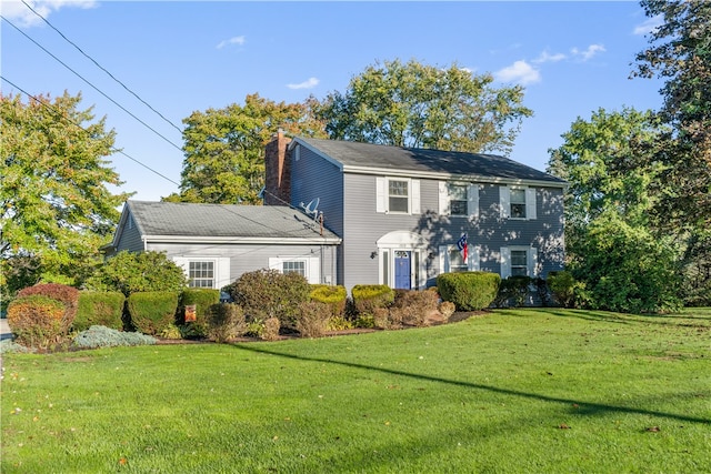 colonial inspired home featuring a front lawn