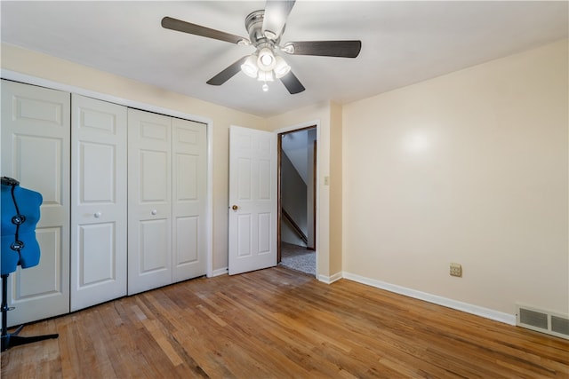 unfurnished bedroom featuring ceiling fan, light wood-type flooring, and a closet