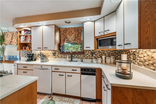 kitchen with white cabinets, white dishwasher, sink, tasteful backsplash, and stainless steel microwave