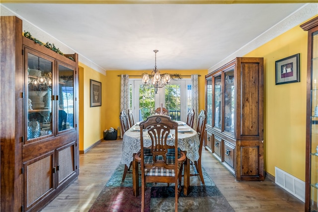 dining room with wood-type flooring and a chandelier