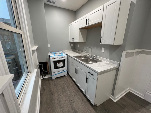 kitchen featuring sink, white cabinetry, dark hardwood / wood-style flooring, and white stove