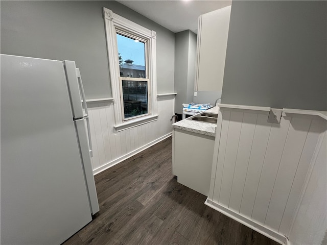 kitchen featuring white cabinets, sink, dark wood-type flooring, and white fridge