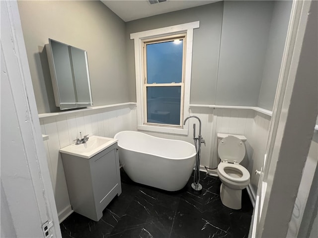 bathroom featuring a bathtub, vanity, and toilet