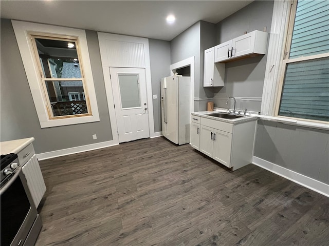 kitchen featuring stainless steel stove, sink, white fridge with ice dispenser, and white cabinetry