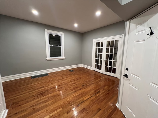 unfurnished room with french doors and dark wood-type flooring