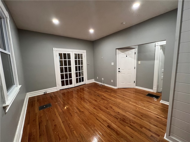 empty room featuring hardwood / wood-style flooring and french doors