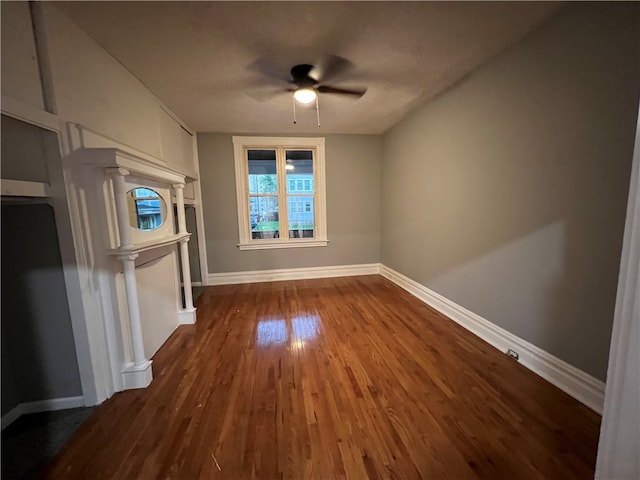 unfurnished room with ceiling fan and dark wood-type flooring