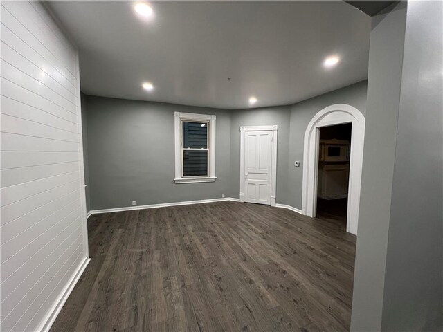 unfurnished room with dark wood-type flooring