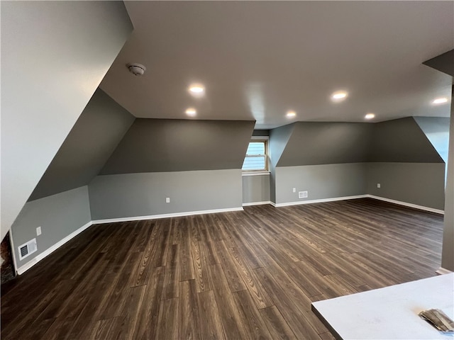 bonus room with dark hardwood / wood-style floors and vaulted ceiling