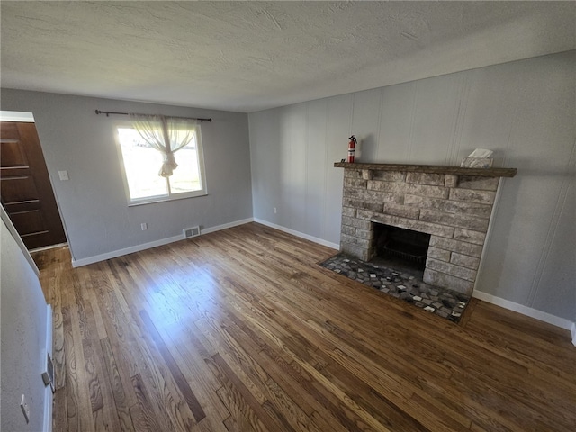 unfurnished living room featuring a textured ceiling, a fireplace, and hardwood / wood-style floors