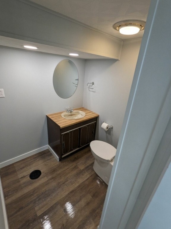 bathroom with wood-type flooring, vanity, and toilet