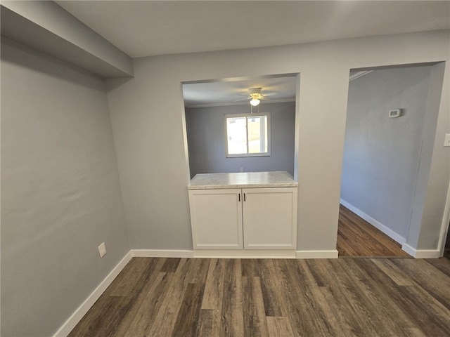 spare room featuring ceiling fan, crown molding, and dark wood-type flooring