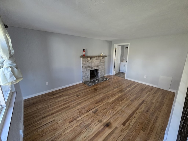 unfurnished living room featuring a fireplace and dark hardwood / wood-style floors