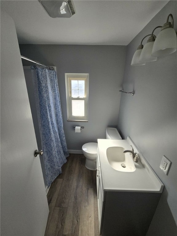 bathroom with vanity, hardwood / wood-style floors, toilet, and curtained shower