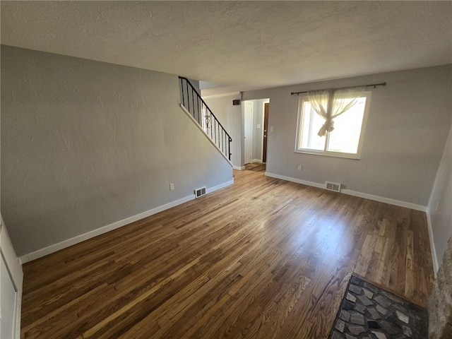 spare room featuring hardwood / wood-style flooring and a textured ceiling