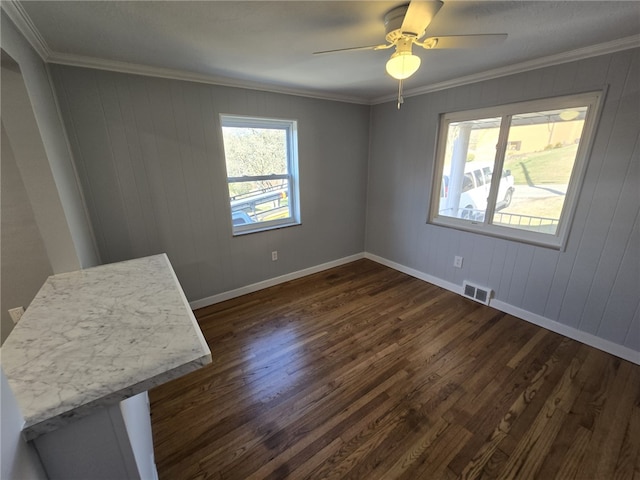 unfurnished room featuring ornamental molding, wooden walls, ceiling fan, and dark hardwood / wood-style flooring