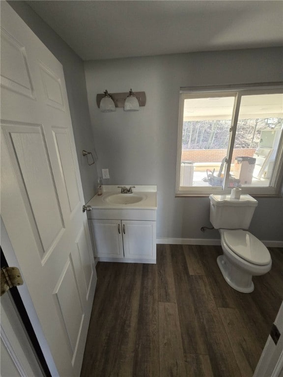 bathroom with wood-type flooring, vanity, and toilet