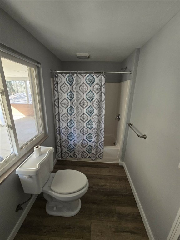 bathroom featuring hardwood / wood-style floors, shower / bath combo, and toilet