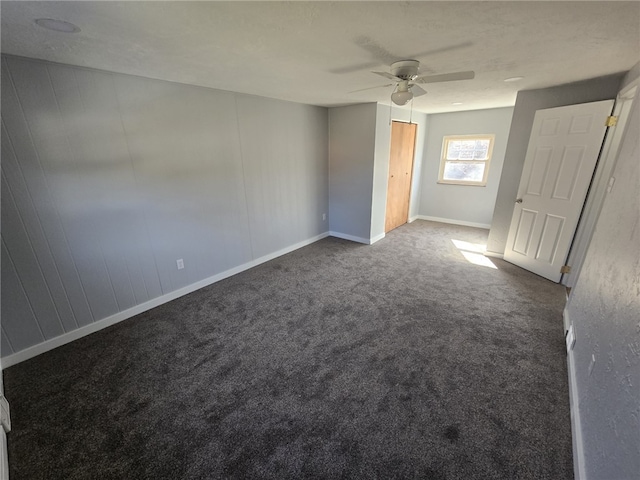 empty room with dark carpet and ceiling fan