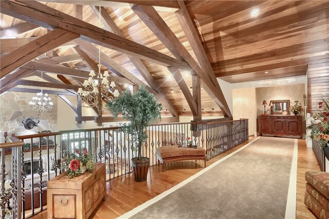 interior space featuring wood ceiling, light hardwood / wood-style floors, a chandelier, and lofted ceiling with beams