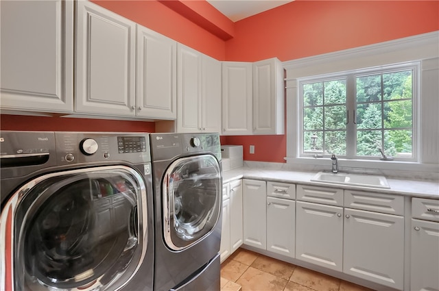 laundry area with washer and dryer, sink, light tile patterned floors, and cabinets