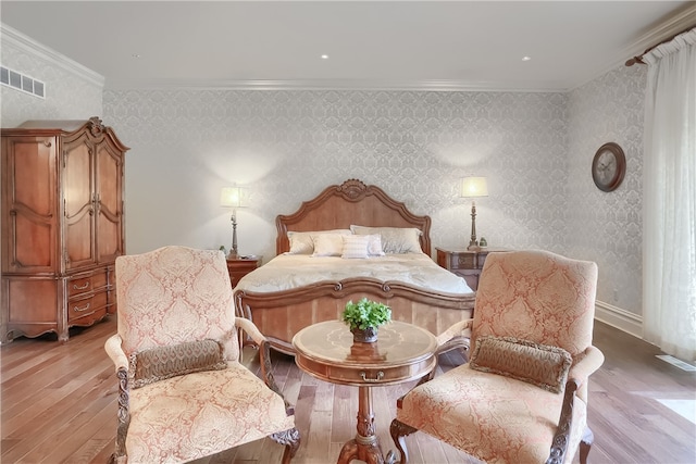 bedroom featuring crown molding and light hardwood / wood-style flooring