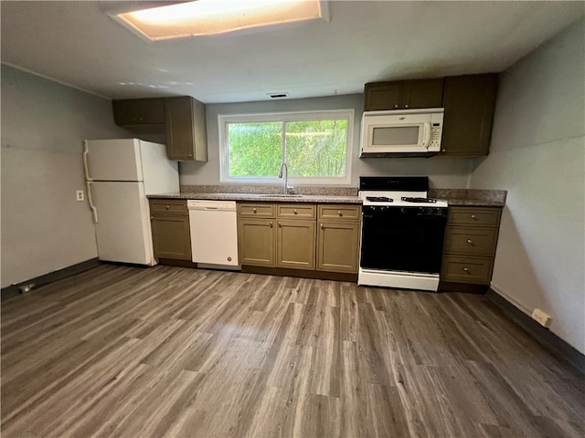 kitchen featuring sink, dark wood-type flooring, and white appliances