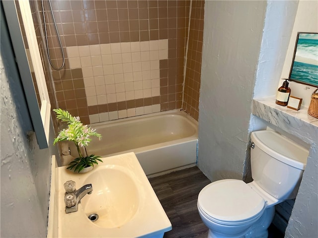 full bathroom featuring vanity, toilet, tiled shower / bath, and hardwood / wood-style floors