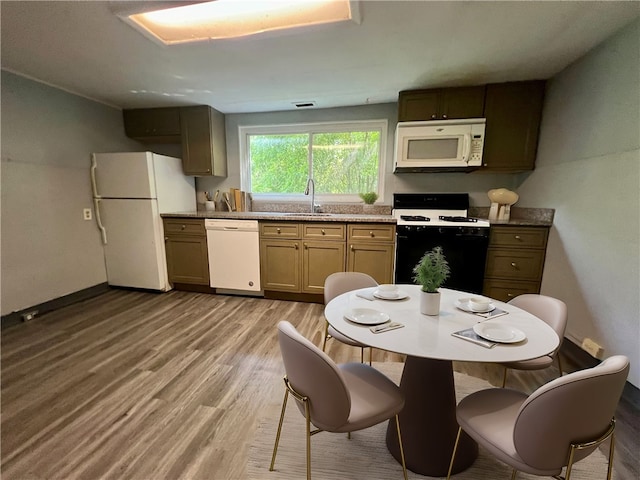 kitchen featuring sink, light wood-type flooring, and white appliances