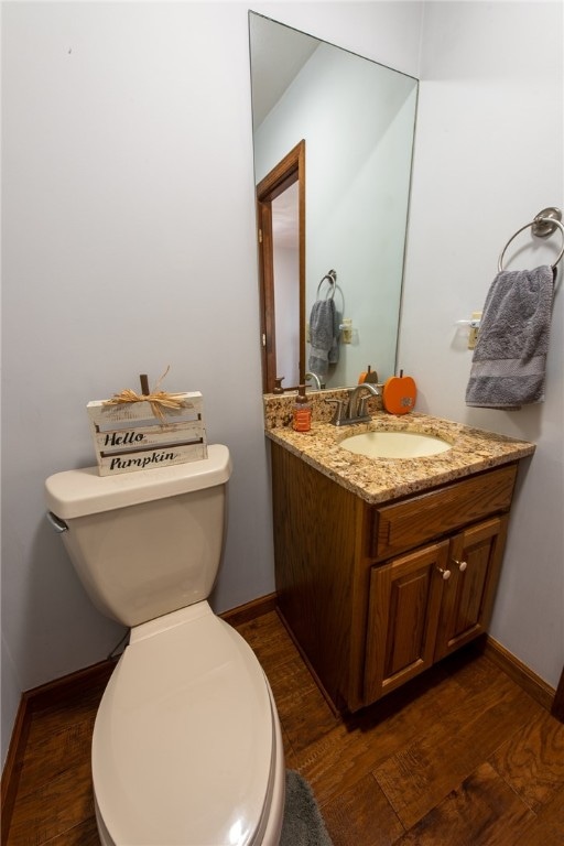 bathroom with vanity, toilet, and hardwood / wood-style flooring