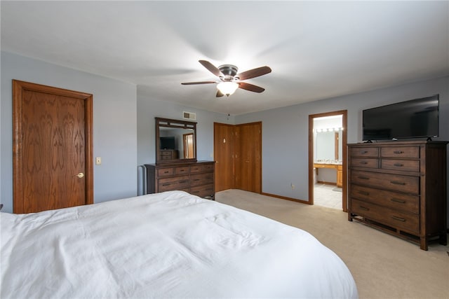 bedroom with light carpet, ceiling fan, and ensuite bath