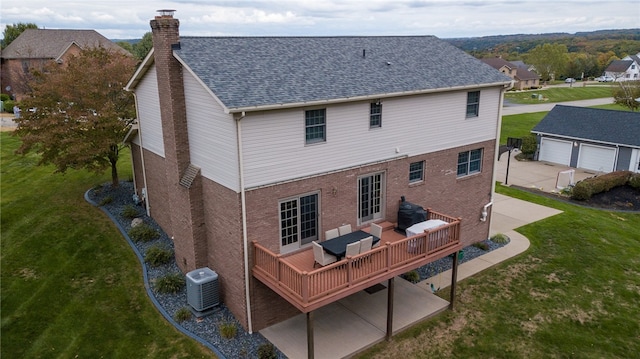 back of house with a garage, central AC, a wooden deck, an outdoor structure, and a lawn