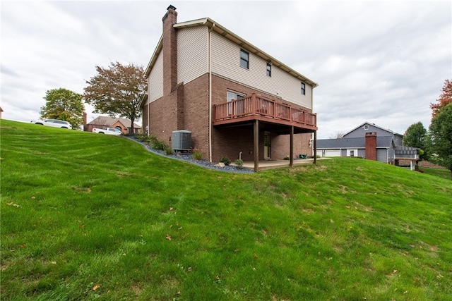 rear view of property featuring a deck, cooling unit, and a lawn