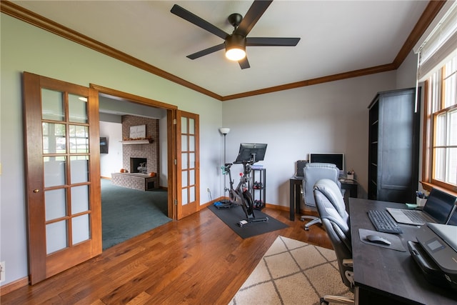 office space featuring ceiling fan, french doors, a brick fireplace, dark hardwood / wood-style floors, and crown molding