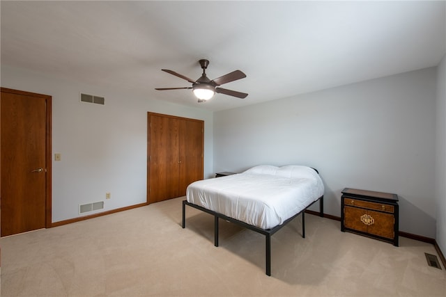 carpeted bedroom with ceiling fan and a closet