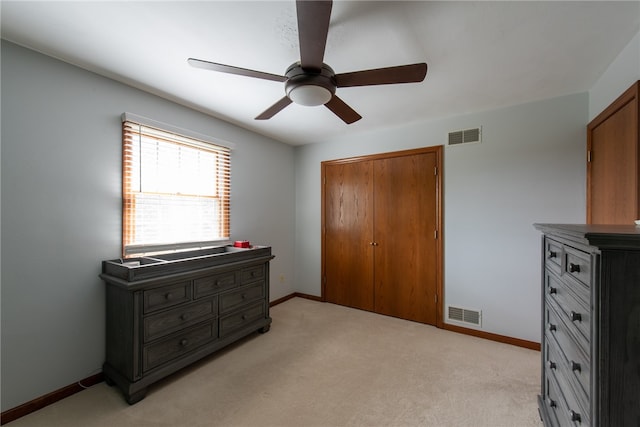 carpeted bedroom featuring ceiling fan and a closet