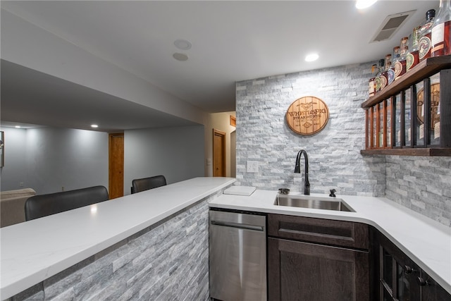 bar featuring dark brown cabinetry, backsplash, and sink