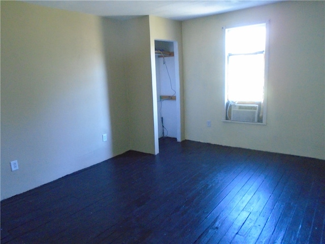 unfurnished room featuring cooling unit and dark wood-type flooring